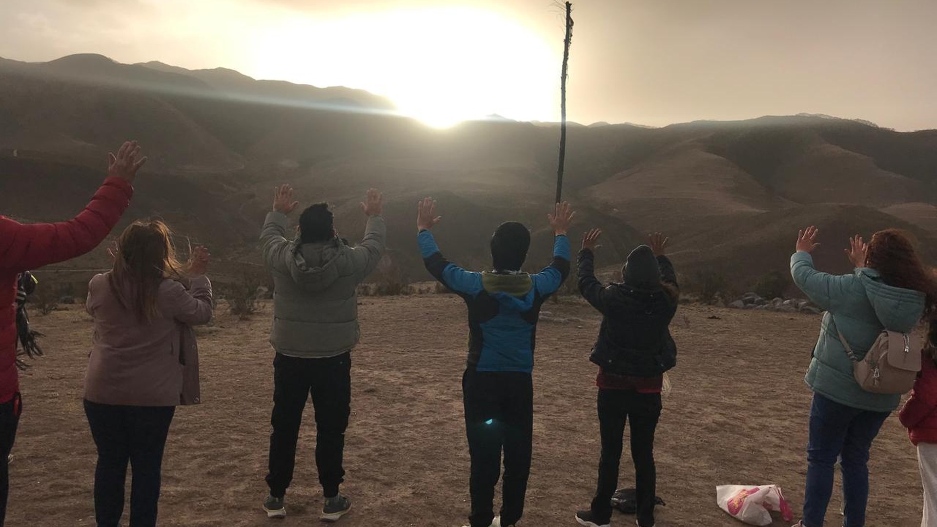 Personas celebrando un amanecer de transformación personal en la montaña