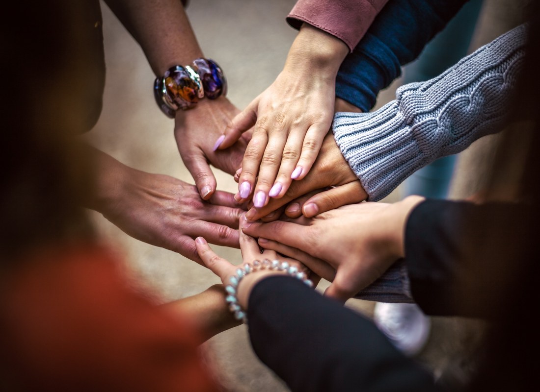 Manos unidas de la comunidad de Fundación Conectar en un círculo de encuentro